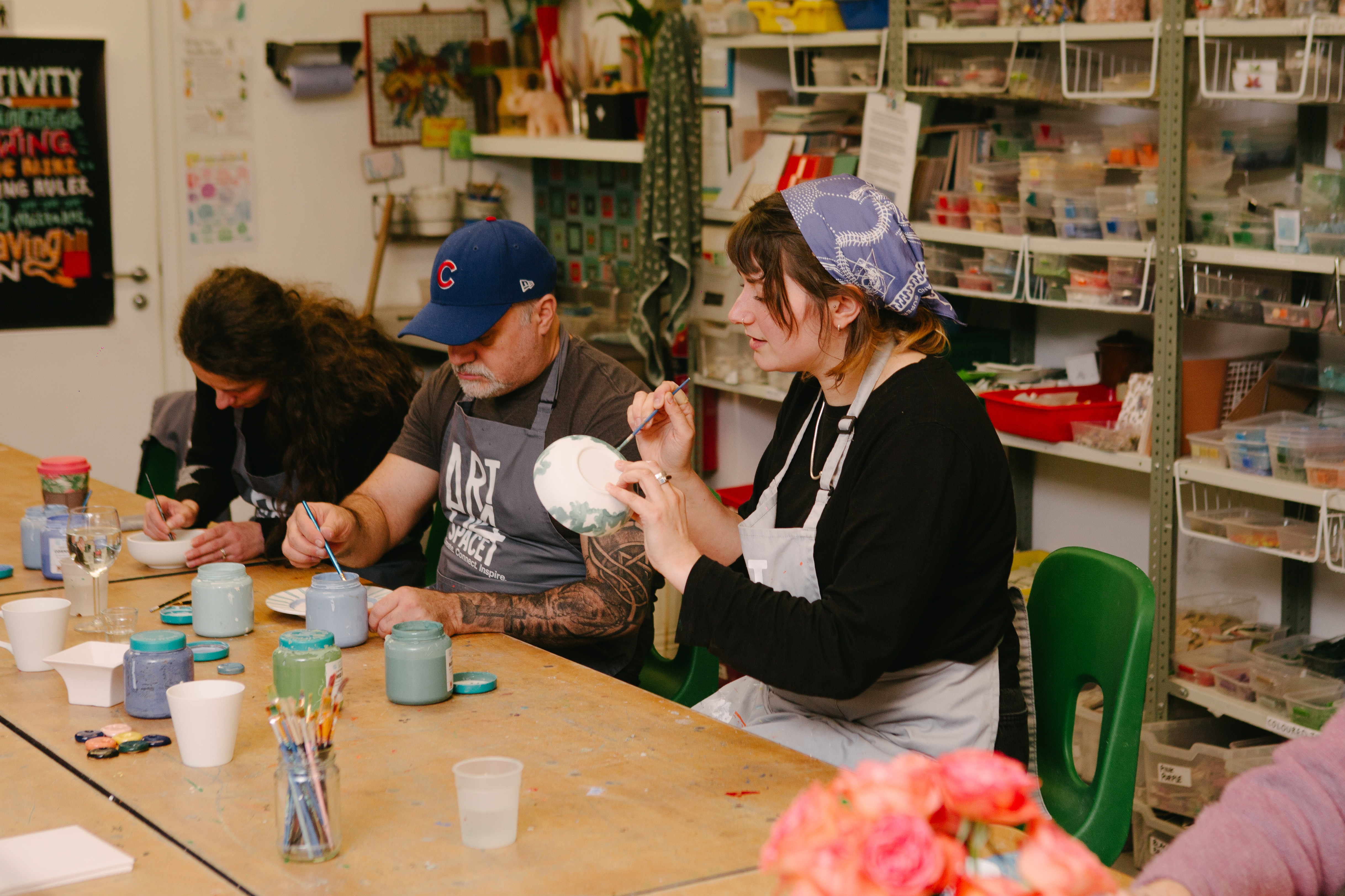 A group of students painting ceramics at a pottery painting class